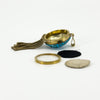 Side view of the open Victorian locket with its removable back components, bail and articulated tassels.