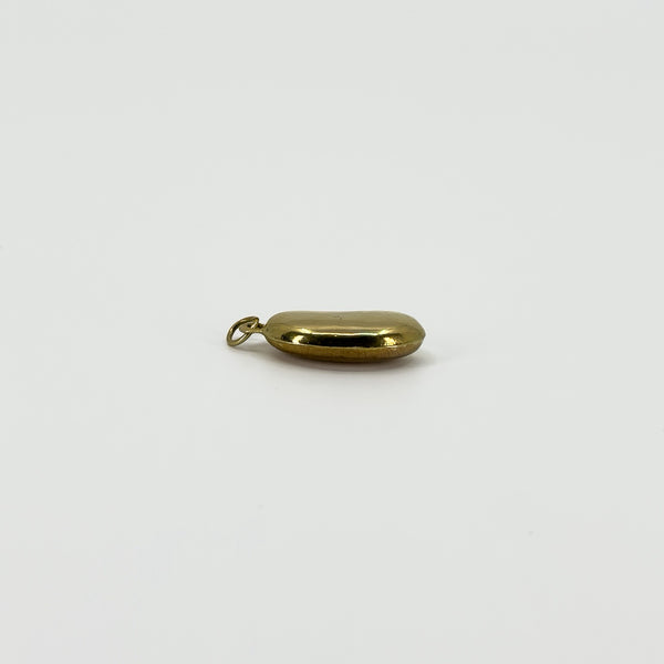 Edge view of vintage 9ct gold lucky bean charm pendant showing the rounded hollow construction and hoop fitting.