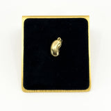 Vintage 9ct gold lucky bean charm pendant displayed on black velvet with polished kidney bean form.