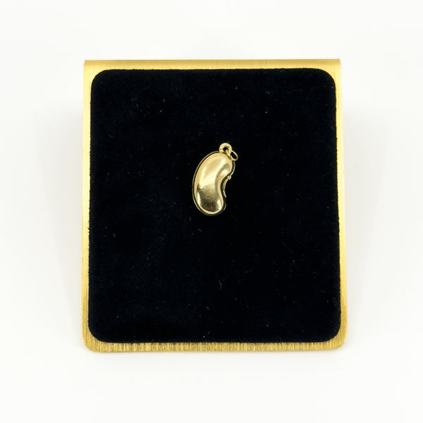 Vintage 9ct gold lucky bean charm pendant displayed on black velvet with polished kidney bean form.