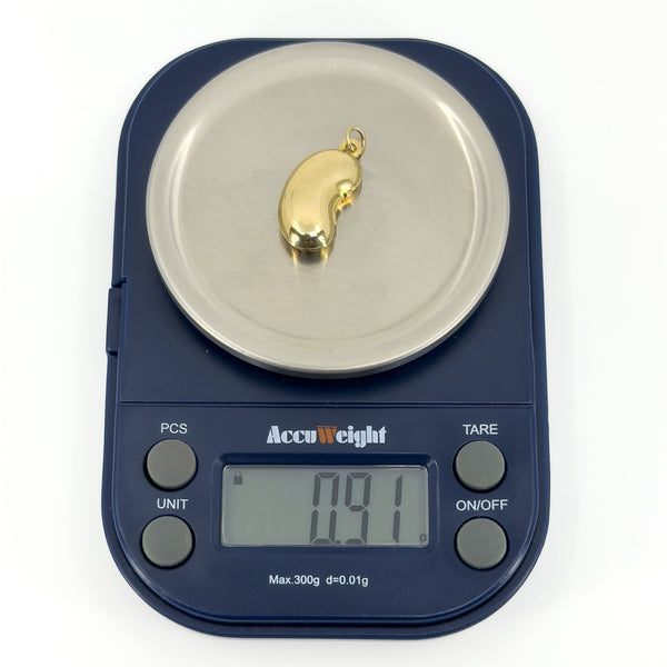 Vintage 9ct gold lucky bean charm pendant weighing approximately 0.91g on digital scales.