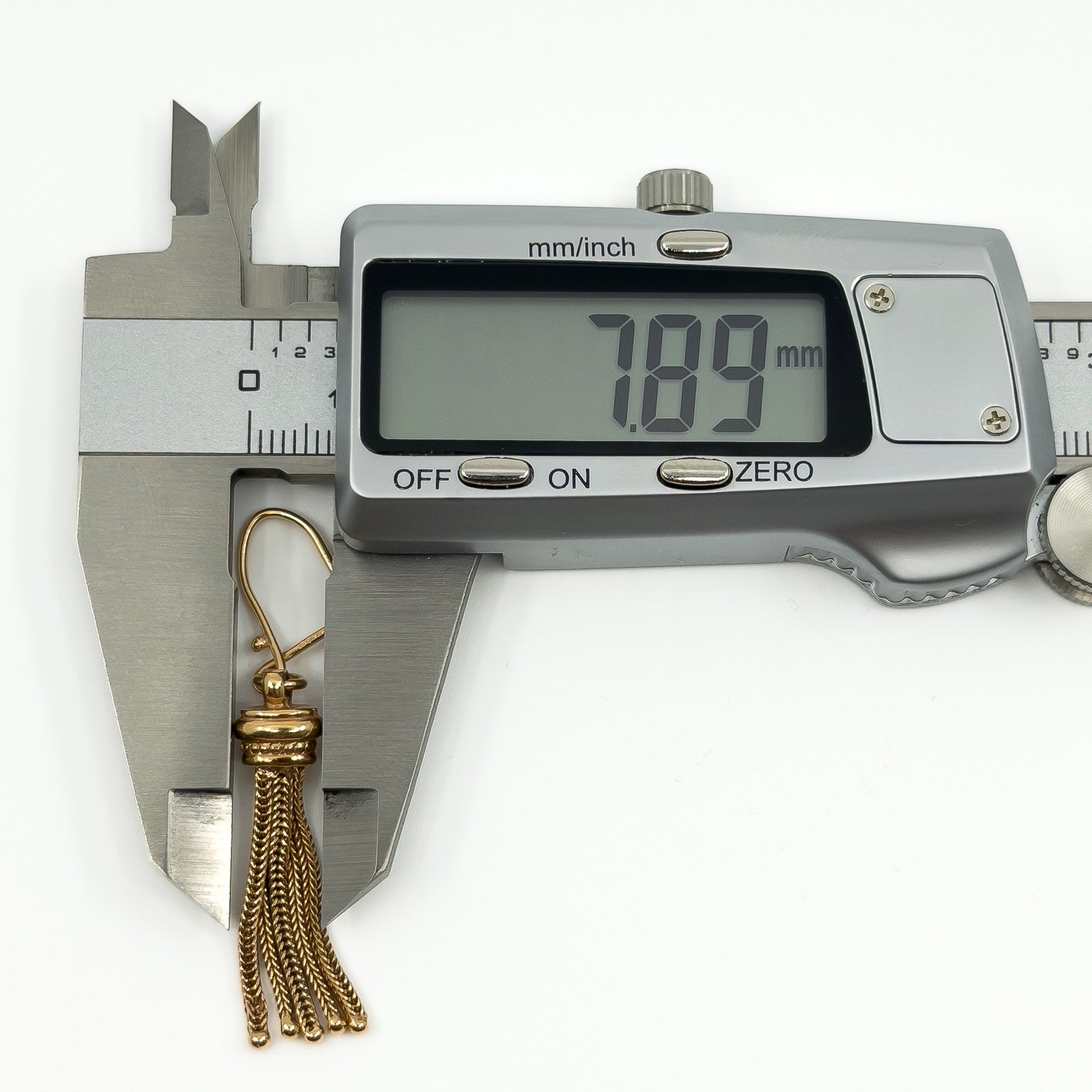 Digital caliper showing the tassel section of a vintage 9ct rose gold Albertina earring measuring about 7.89mm wide.