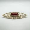 Sterling silver brooch with cabochon carnelian in detailed cut-out setting