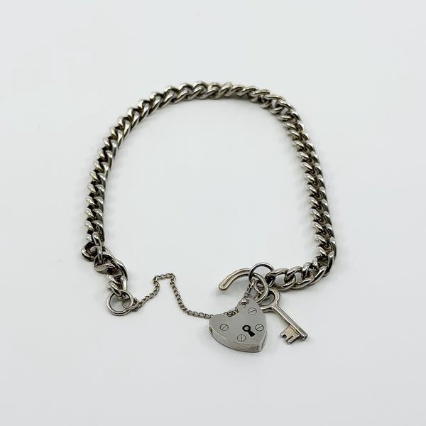 Vintage sterling silver curb bracelet with open heart padlock, key charm and safety chain.