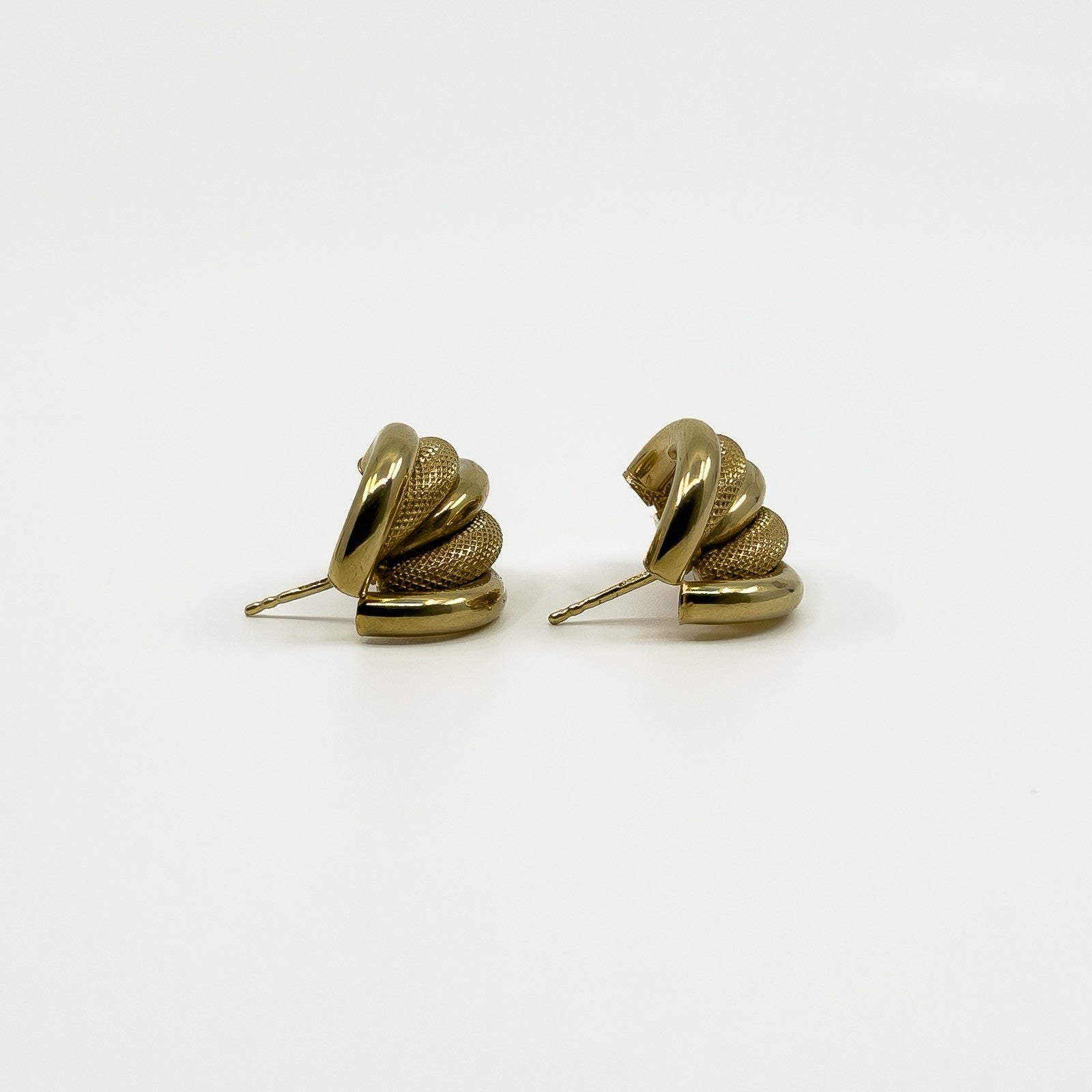 Side view of vintage 9ct gold half hoop earrings showing polished and mesh-textured curved strands.
