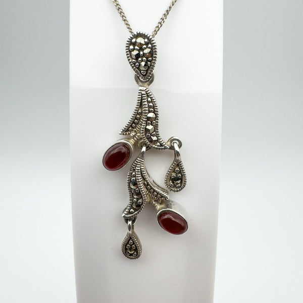 Detailed view of vintage carnelian and marcasite pendant on stand