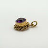 Angled view of amethyst pendant showing gold setting and jump ring