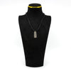 Vintage sterling silver ingot pendant shown on display cord with engraved bird and leaf design.