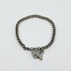Vintage sterling silver curb link bracelet with heart padlock and key charm laid flat.