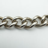 Close-up of vintage silver curb bracelet links with full British hallmarks