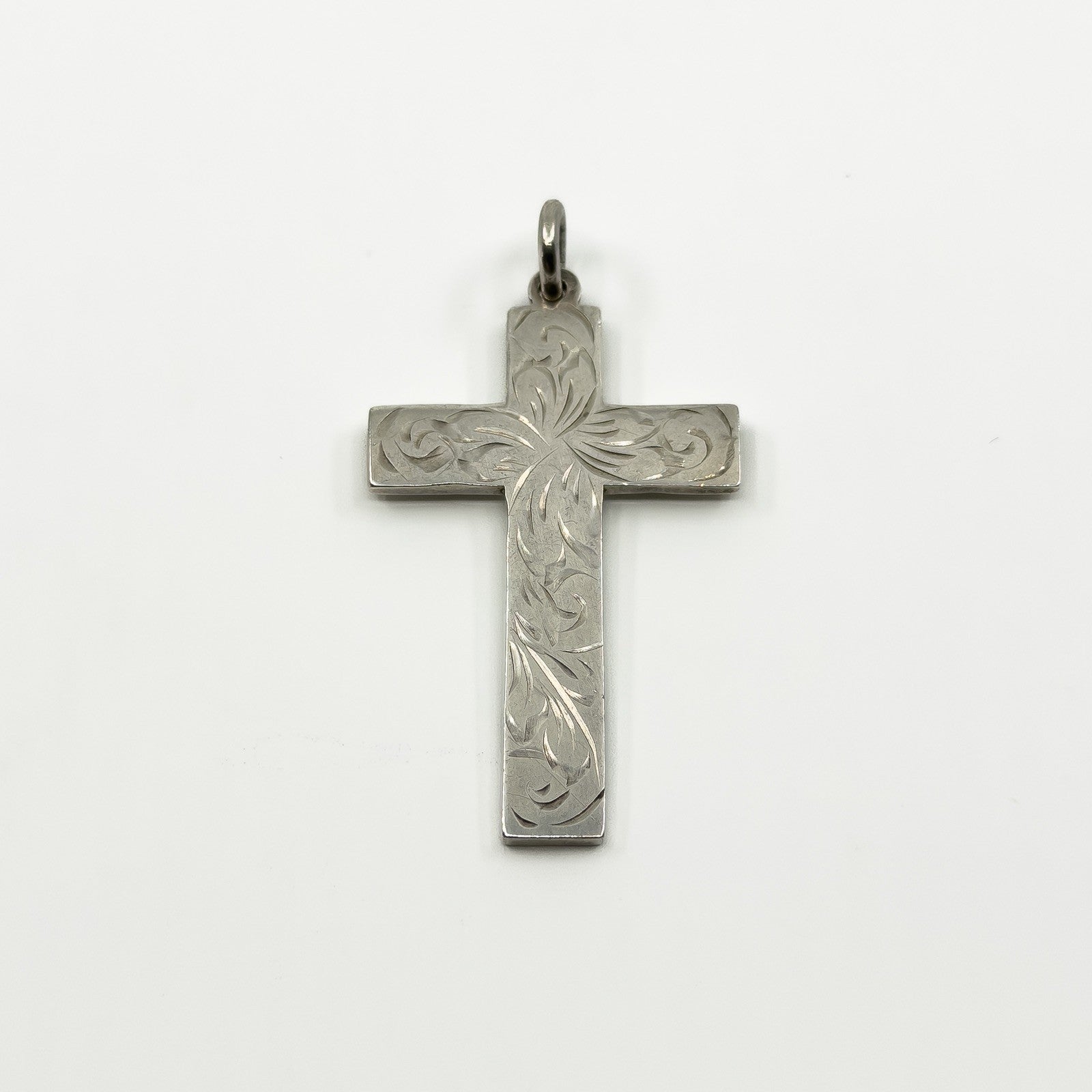 Vintage sterling silver cross pendant with engraved foliate detail and a plain bail.