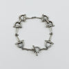 Vintage sterling silver horsebit snaffle bracelet with T Bar closure shown in a full flat view.