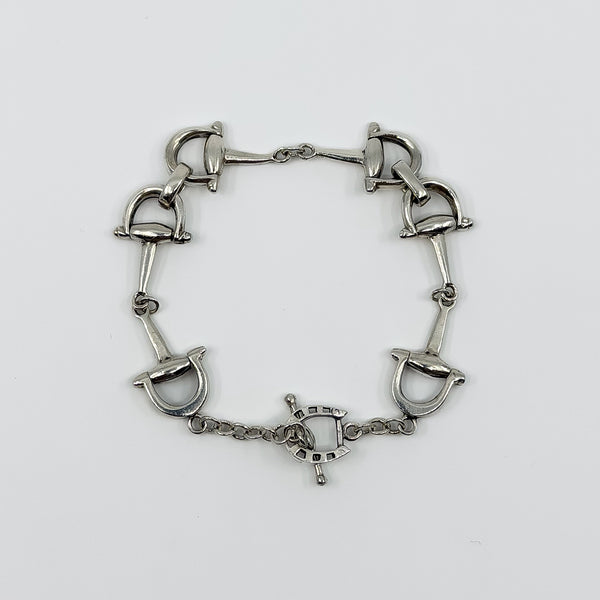 Vintage sterling silver horsebit snaffle bracelet with T Bar closure shown in a full flat view.