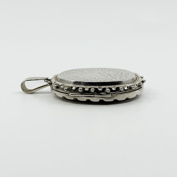 Side profile of vintage sterling silver oval locket showing the raised beaded edge and large bail