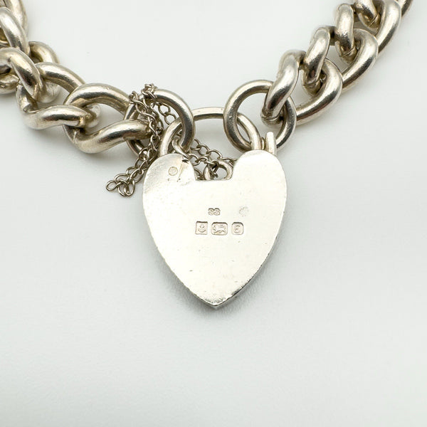 Heart padlock on silver bracelet showing hallmark SS, anchor, lion, and letter E