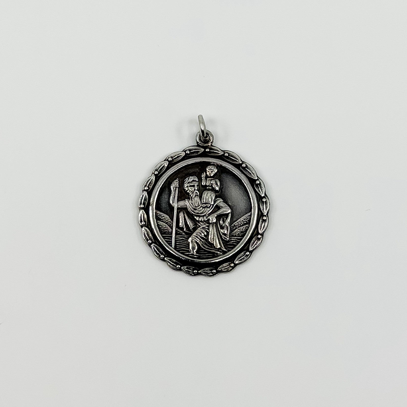 Vintage sterling silver St Christopher pendant charm with jump ring on white background.