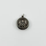 Vintage sterling silver Virgin Mary Christian photo locket pendant with jump ring on white background.
