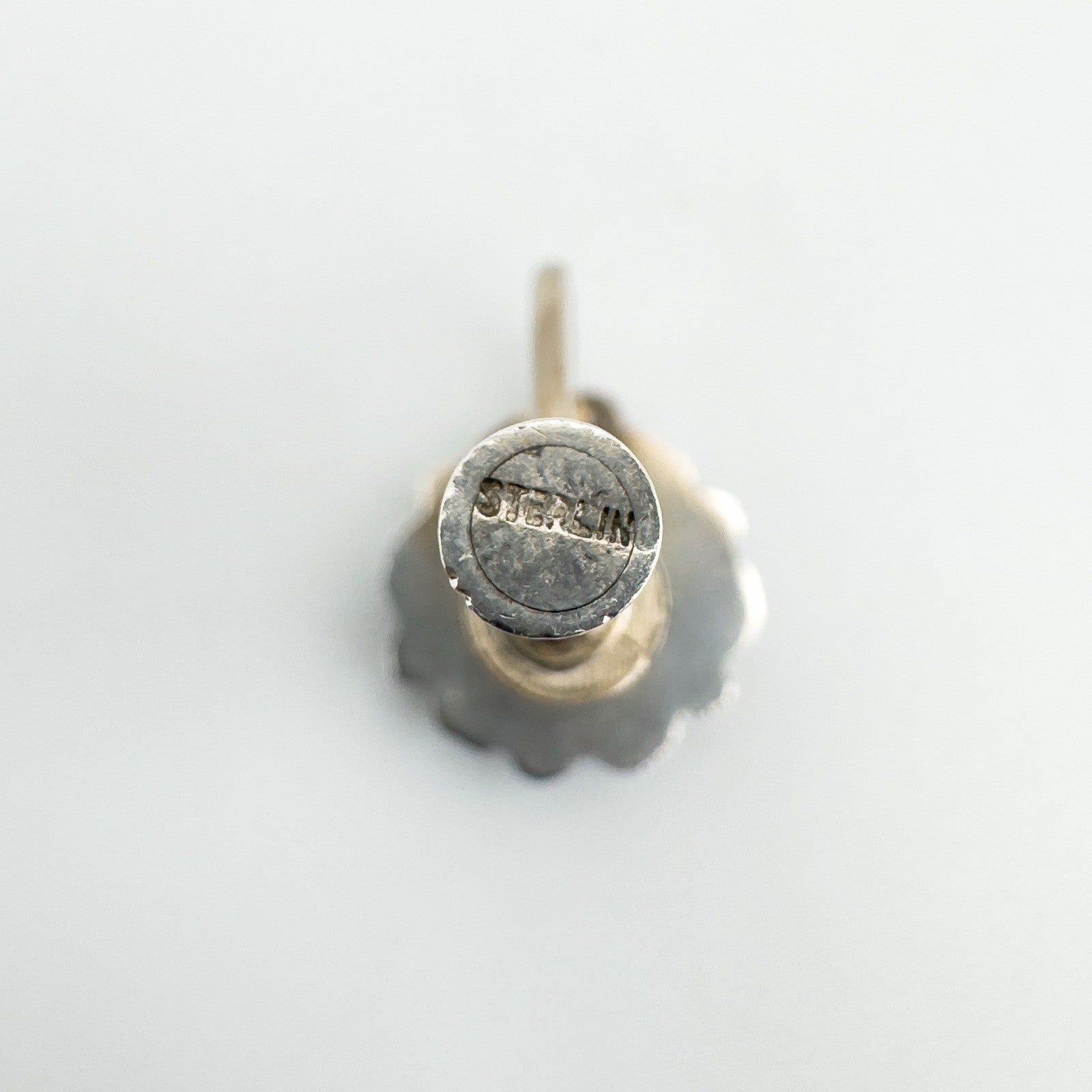 Back view of screw back earrings showcasing hallmark and fastening