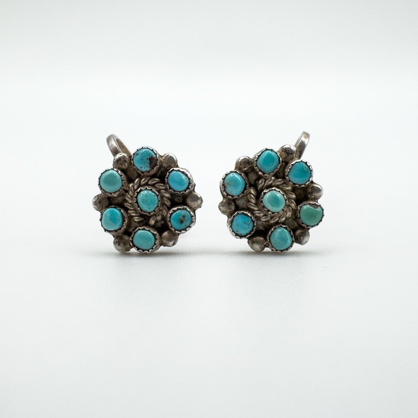 Earrings presented on a neutral background emphasizing turquoise color