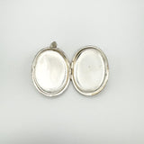 Interior of oval sterling silver locket showing both inner compartments