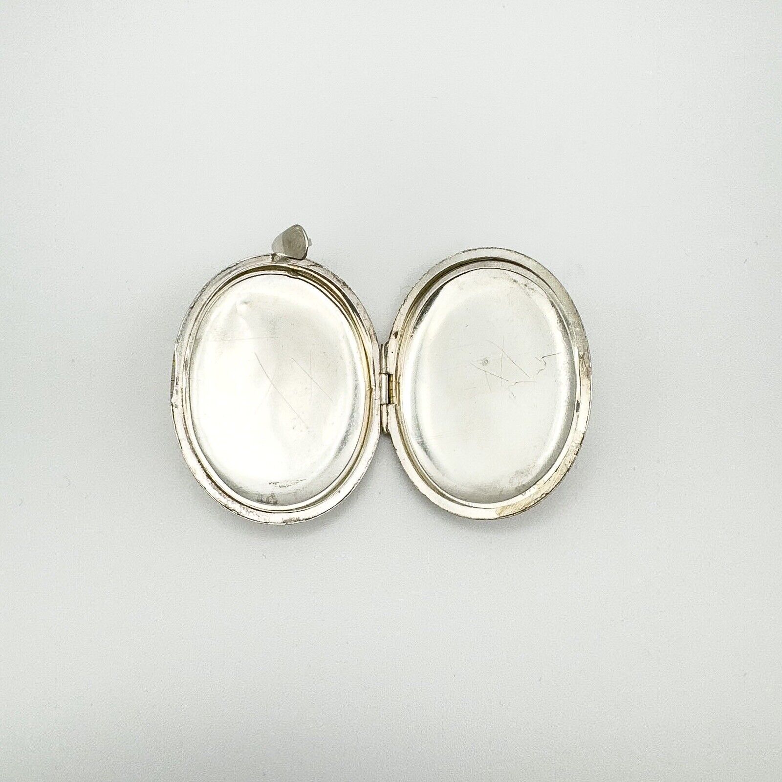 Interior of oval sterling silver locket showing both inner compartments