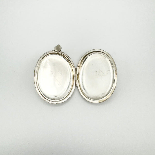 Interior of oval sterling silver locket showing both inner compartments