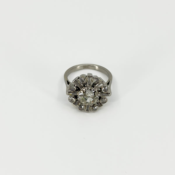 Front view of vintage platinum 2.70ct diamond cluster ring with old cut centre and geometric surround.