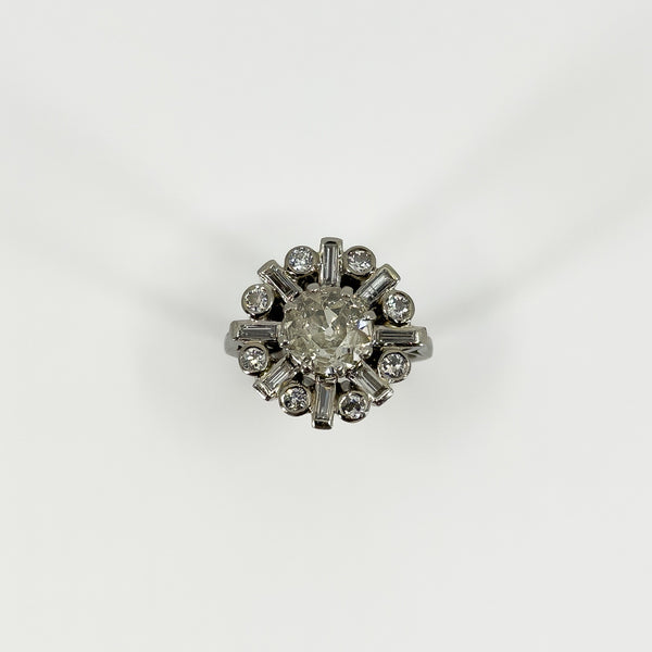 Front view of vintage platinum 2.70ct diamond cluster ring with old cut centre and alternating diamond surround.