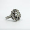 Angled close-up of vintage platinum diamond cluster ring showing the old cut centre and surrounding diamonds.