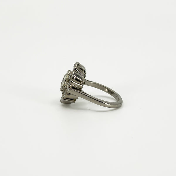 Opposite side view of vintage platinum diamond cluster ring showing the raised cluster and tapered shoulder.