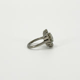 Side profile of vintage platinum diamond cluster ring showing the raised setting and tapered platinum band.
