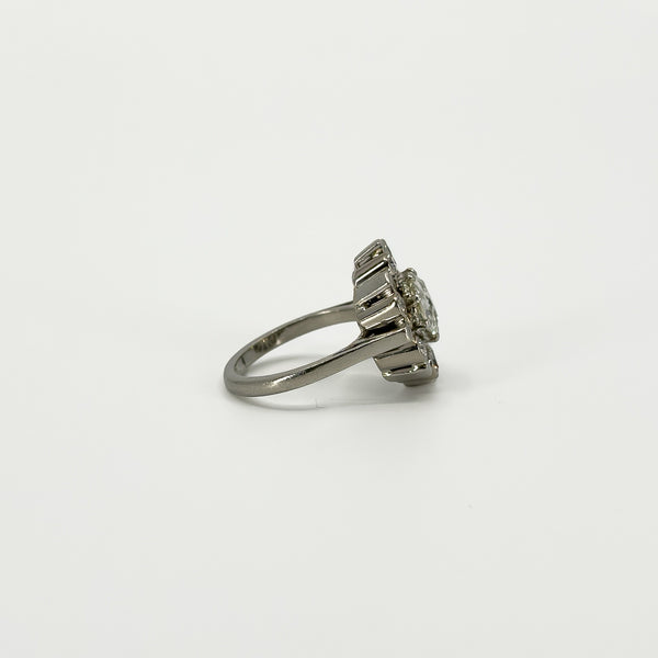 Side profile of vintage platinum diamond cluster ring showing the raised setting and tapered platinum band.