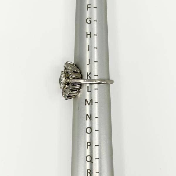 Vintage platinum diamond cluster ring shown side-on on a ring mandrel at UK Size K.