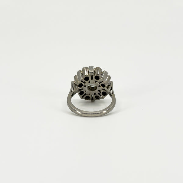 Underside of vintage platinum diamond cluster ring showing the open-backed gallery and platinum band.