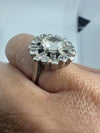 Side view of vintage platinum diamond cluster ring worn on the hand, showing the raised cluster setting.