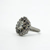 Angled front view of vintage platinum cluster ring with old cut centre and alternating round and baguette diamonds.