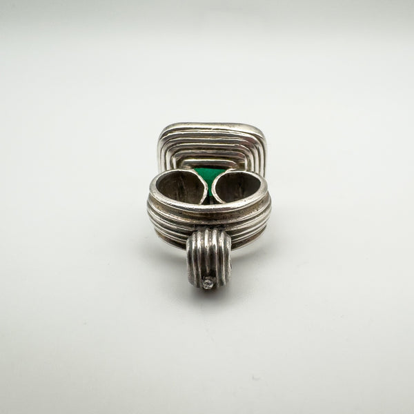 Side view of vintage silver pendant showing scrolled fob-style design