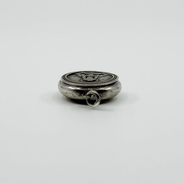 Low side view of vintage sterling silver Virgin Mary photo locket pendant with jump ring.