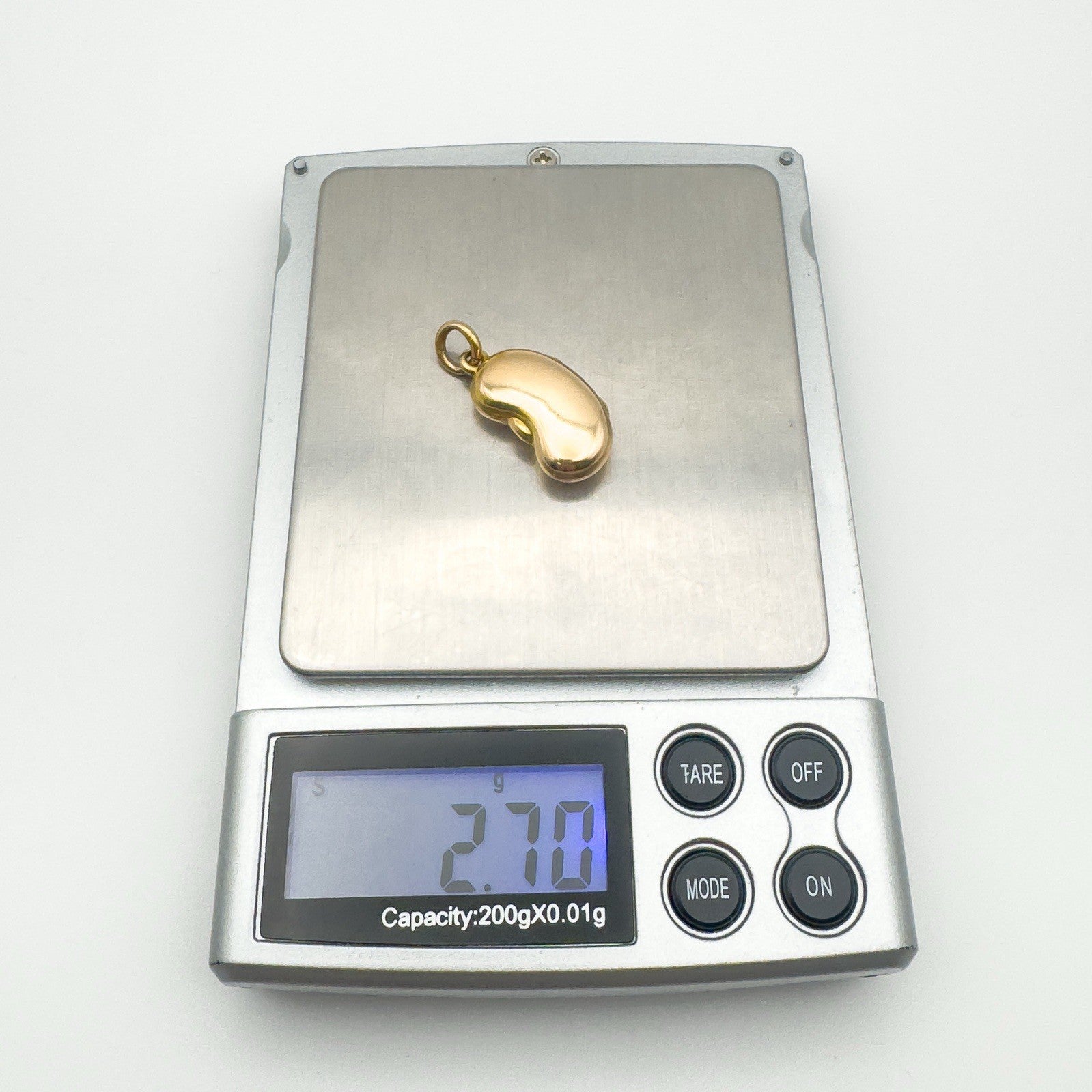 Digital scale showing the locket pendant weighs approximately 2.7g