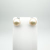 White pearl stud earrings displayed on white earring stand