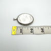 Measuring the width of chunky oval locket at 33mm with tape