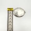 Oval sterling silver locket shown next to tape measure for width reference