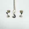 Sterling silver diamond pendant with matching earrings laid flat